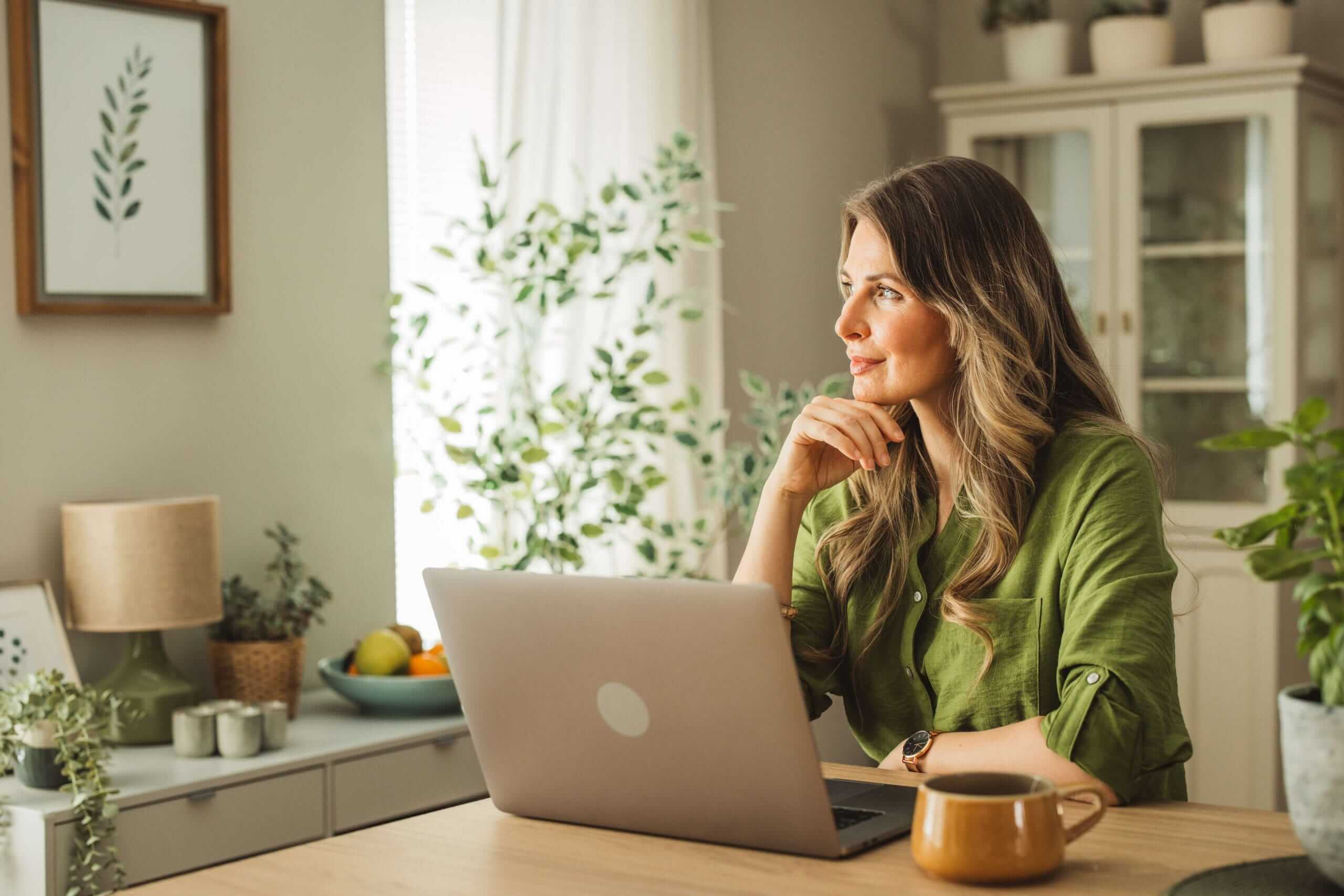 Woman with a lap top smiling looking in the distance