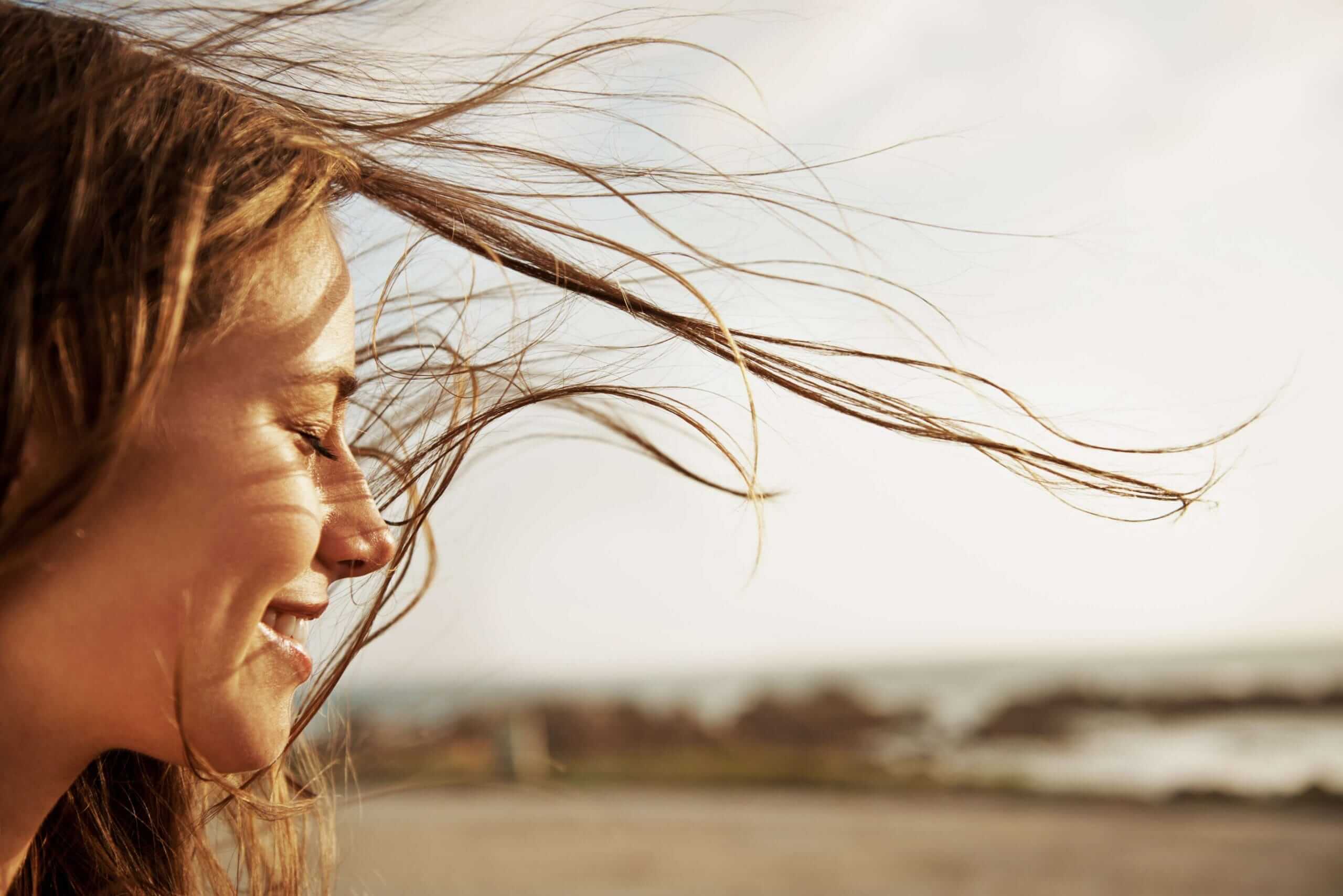 Woman's hair in the wind she is smiling