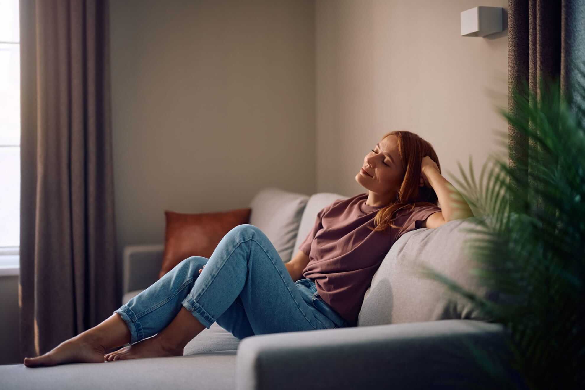 a woman lounging on a gray, modern sofa