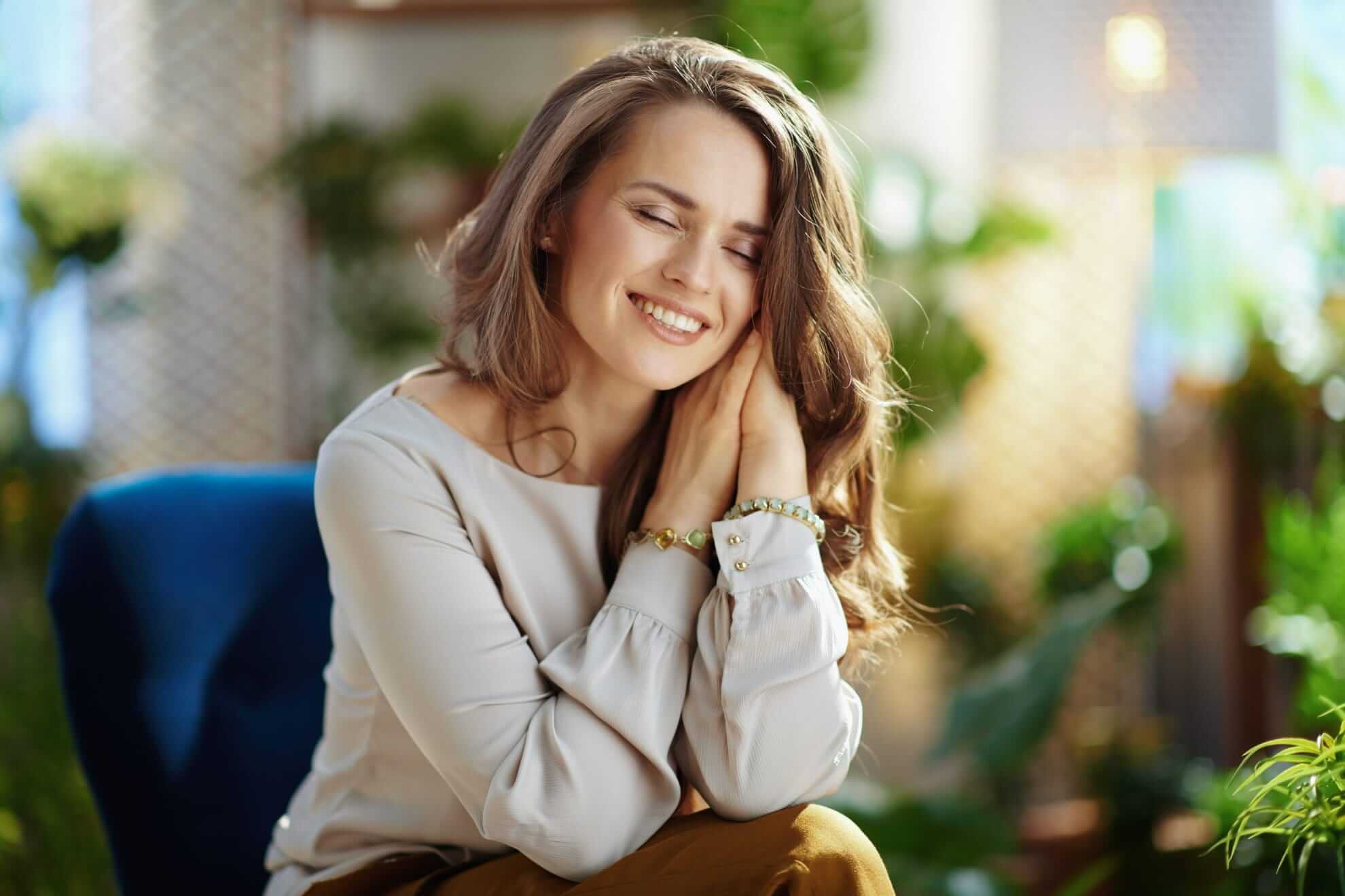 a relaxed, stylish woman in a grey blouse