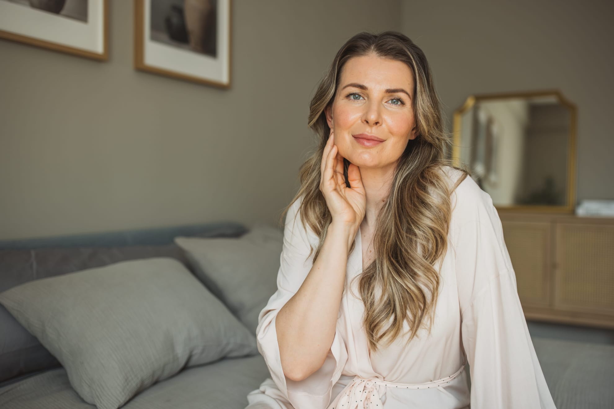 smiley woman sitting on a bed