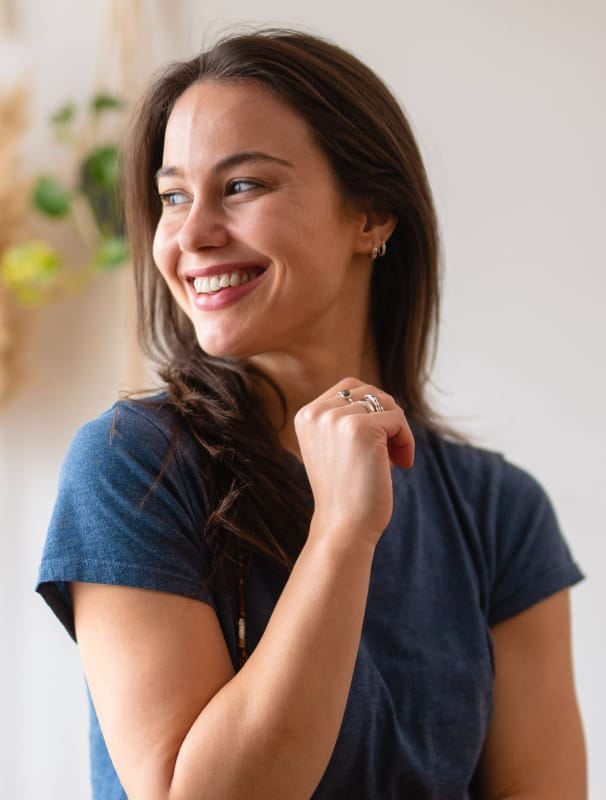 smiley young woman wearing small, simple sterling silver hoop earrings
