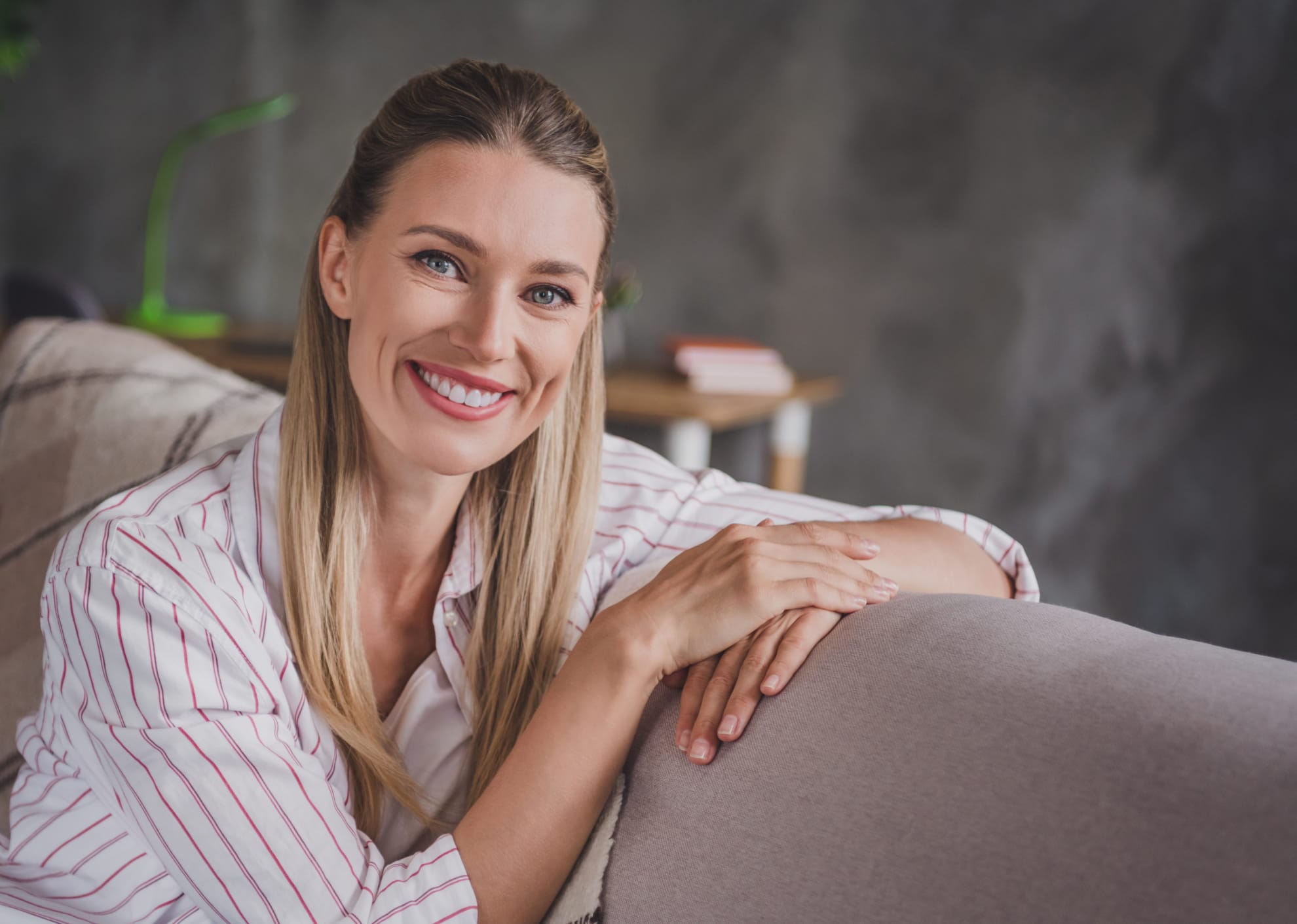 happy woman sitting on a sofa