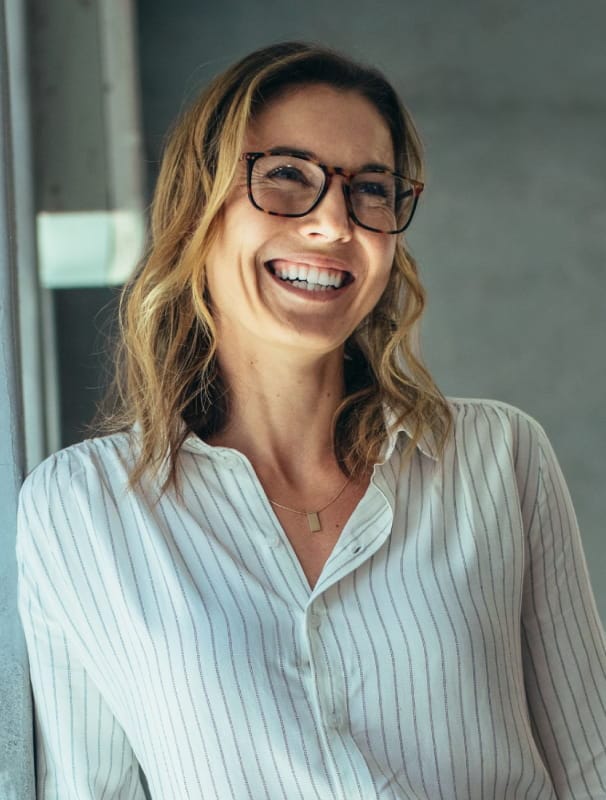 smiley woman wearing glasses and a striped button-up shirt