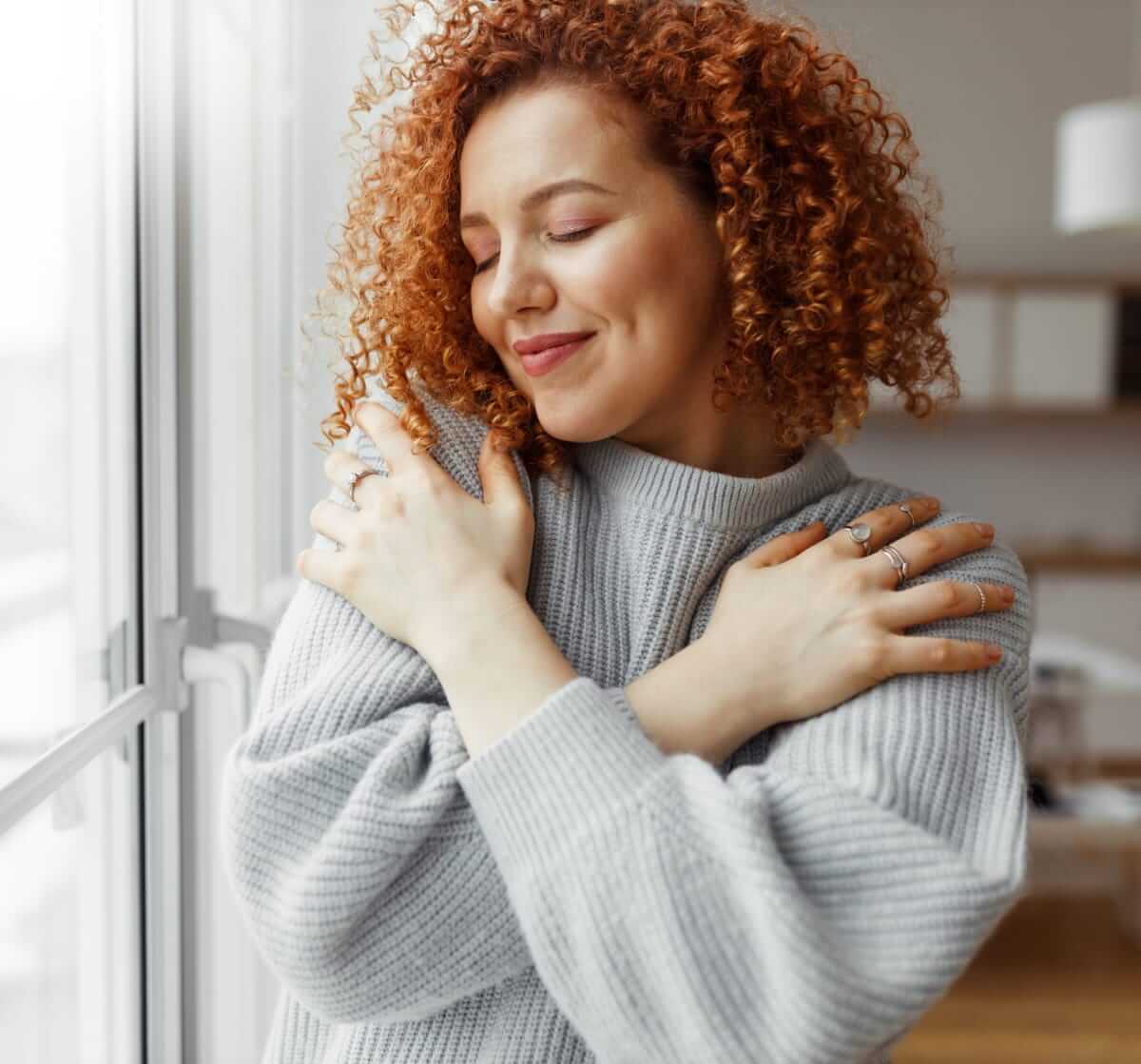 young woman embracing herself